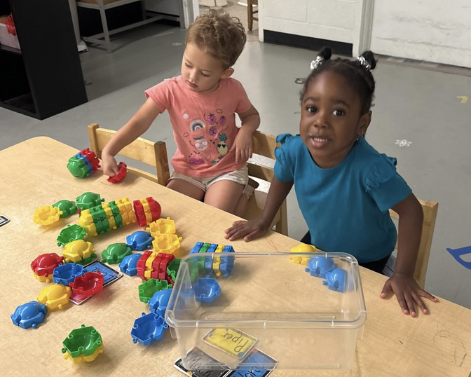 Two toddlers playing with blocks as part of the Lil Beakers child care program at The Lab Child Care Center in Easton, MD.