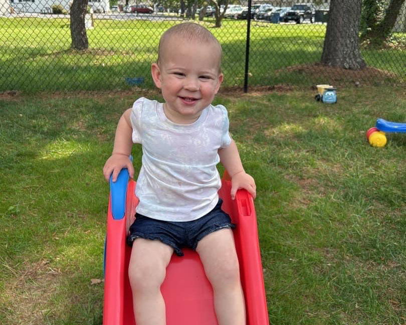 Toddler sitting on slide as part of the Tiny Tubes program at The Lab Child Care Center in Easton, MD.